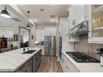 Bright kitchen with white cabinetry, a gas range, stainless steel appliances, and an island at 1906 N 140Th Dr, Goodyear, AZ 85395