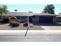 Single-story home featuring neutral colors, a well-maintained front yard, and an attached two-car garage at 19215 N Concho Cir, Sun City, AZ 85373