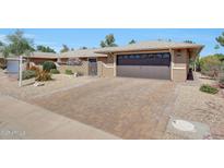 Charming home with a two-car garage, paver driveway, and desert landscaping at 19215 N Concho Cir, Sun City, AZ 85373