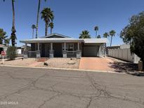Charming single-story home with well-maintained landscaping and an attached carport on a sunny day at 201 S Greenfield S Rd # 222, Mesa, AZ 85206