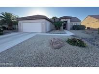 Charming single-story home featuring a two-car garage and low maintenance desert landscaping in front yard at 20376 N Coronado Way, Surprise, AZ 85374
