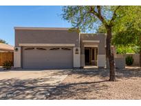 Charming single-story home featuring a two-car garage, neutral stucco exterior, and easy to maintain desert landscaping at 3241 E Hampton Ln, Gilbert, AZ 85295
