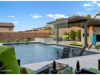Stunning backyard pool with water feature, covered patio, and lounge seating; perfect for outdoor entertaining at 5457 S Benton --, Mesa, AZ 85212
