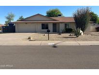Charming single-story home featuring a well-maintained front yard with desert landscaping and a spacious two-car garage at 6533 E Kelton Ln, Scottsdale, AZ 85254