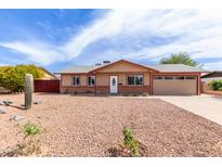 Charming single-story home featuring a well-maintained yard and an attached garage for convenient parking at 655 E Hondo Ave, Apache Junction, AZ 85119