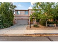 Inviting two-story home showcasing desert landscaping, a two-car garage, and covered front porch at 1222 E Canyon Trl, San Tan Valley, AZ 85143