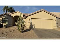 Charming home featuring a two-car garage, desert landscaping and mature cacti for added curb appeal at 14878 W Verde Ln, Goodyear, AZ 85395