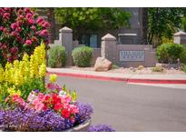 Welcoming Villages North entrance sign surrounded by vibrant flowers and desert landscaping at 15252 N 100Th St # 1147, Scottsdale, AZ 85260