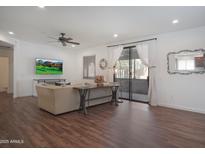 Open-concept living room with wood floors, neutral decor, and a sliding glass door to a patio at 15252 N 100Th St # 1147, Scottsdale, AZ 85260