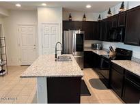 Bright, modern kitchen features a large island, stainless appliances and dark cabinetry at 1718 S 82Nd Way, Mesa, AZ 85209