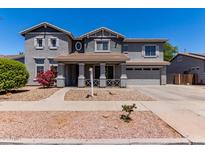 Charming two-story home with a well-manicured front yard and attached two-car garage, painted in neutral gray tones at 18868 E Canary Way, Queen Creek, AZ 85142