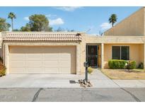 Charming single-story home featuring a tan exterior, a two-car garage, and a well-manicured lawn at 2116 W Marlette Ave, Phoenix, AZ 85015