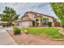 Charming two-story home with a well-manicured lawn, mature trees and a three-car garage at 2218 E Anchor Dr, Gilbert, AZ 85234