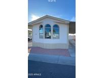 Charming home exterior featuring arched windows and a well-maintained yard, perfect for comfortable living at 320 E Mckellips Rd # 152, Mesa, AZ 85201