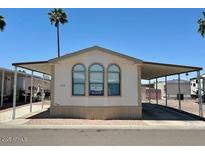 Charming single-Gathering home featuring a covered carport and well-maintained landscaping at 320 E Mckellips Rd # 152, Mesa, AZ 85201