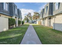 A peaceful community with lush green lawns and well-maintained townhomes under a bright blue sky at 3222 W Royal Palm Rd, Phoenix, AZ 85051