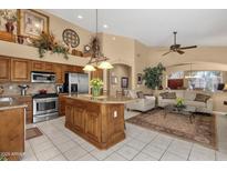 Open-concept kitchen features stainless steel appliances, tile floors, and spacious island with granite countertops at 4720 E Bighorn Ave, Phoenix, AZ 85044