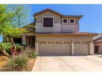 Tan two-story home with a three-car garage, desert landscaping, and a red tile roof at 4834 E Robin Ln, Phoenix, AZ 85054