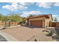 Charming home with brick driveway, desert landscaping, and tile roof, under a partly cloudy sky at 6937 E Sierra Morena Cir, Mesa, AZ 85207