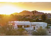 Stunning modern home with mountain views, desert landscaping, and bright sunset at 8520 E Cactus Wren Rd, Scottsdale, AZ 85250