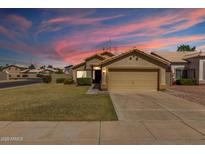 Charming single-story home boasts a well-manicured lawn and neutral-toned exterior with a two-car garage at 1350 E Vaughn Ave, Gilbert, AZ 85234