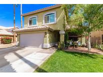 Charming two-story home features a lush front lawn, attached two car garage, and well-manicured landscaping at 1560 E Flint St, Chandler, AZ 85225
