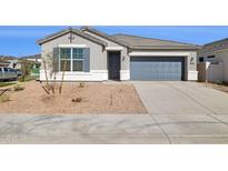 Charming single-story home featuring a xeriscaped front yard, gray stucco, and a two-car garage at 17749 W Onyx Ave, Waddell, AZ 85355