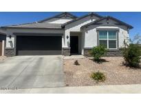 Charming single-story home featuring a neutral color scheme, a two-car garage, and a well-maintained, low-water, xeriscaped front yard at 17755 W Onyx Ave, Waddell, AZ 85355