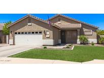 Charming single-story home featuring an attached two-car garage, manicured lawn, and desert landscaping at 1926 S Longspur Ln, Gilbert, AZ 85295