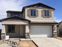 Charming two-story home featuring neutral stucco, decorative shutters, stone accents, and a two-car garage at 22368 W Monona Ln, Surprise, AZ 85387