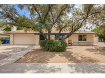 Charming single-story home featuring a covered front porch and mature trees in a well-maintained landscape at 2745 S Emerson Cir, Mesa, AZ 85210