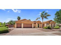Charming single-story home with a three-car garage, desert landscaping and mature palm trees at 4204 S Winter Ln, Gilbert, AZ 85297