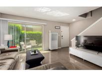 Bright living room with a modern entertainment center and sliding door access to a charming outdoor patio at 4600 N 68Th St # 302, Scottsdale, AZ 85251