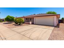 Single story home featuring an expansive driveway and an attached two car garage in a suburban neighborhood at 5055 E Enid Ave, Mesa, AZ 85206