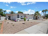 Charming single-story home featuring a two-car garage, neutral stucco, rock landscaping, and palm trees at 526 W Kings Ave, Phoenix, AZ 85023