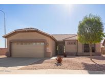 Tan single-story home featuring low maintenance desert landscaping and a two car garage at 6984 S Newport Ct, Chandler, AZ 85249