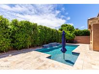 Inviting pool area with a waterfall feature, lush greenery, blue skies, and space for outdoor seating at 903 E Jacob St, Chandler, AZ 85225
