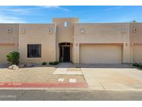 Inviting tan stucco home featuring a two-car garage, desert landscaping, and a charming front entrance at 1650 S Crismon Rd # 86, Mesa, AZ 85209