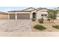 Charming single-story home boasts a neutral color palette, three-car garage, and beautiful desert landscaping at 1749 W Posada St, Coolidge, AZ 85128