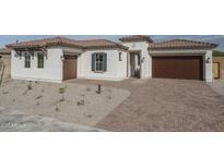 Charming single-story home with a desert-scape front yard, a brick driveway, and a two-car garage at 18564 W Cathedral Rock Dr, Goodyear, AZ 85338