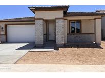 Charming single-story home featuring a brick facade, a driveway, and a well-manicured lawn at 20615 N 226Th Dr, Surprise, AZ 85387