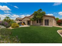 Expansive backyard with lush green grass, mature trees, and a sparkling pool at 22322 N 77Th St, Scottsdale, AZ 85255