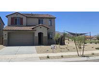 Inviting two-story home featuring a two-car garage, desert landscaping, and a charming entryway at 22359 W Monona Ln, Surprise, AZ 85387