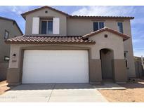 Two-story home features a stucco facade, attached two-car garage, and red tile roof at 22359 W Monona Ln, Surprise, AZ 85387