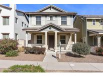 Charming two-story home featuring a covered front porch, neutral siding, and manicured landscaping at 2947 N Evergreen St, Buckeye, AZ 85396