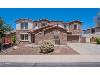 Charming two-story home with stone accents, a well-manicured lawn, and a welcoming two car garage at 3574 E Glacier Pl, Chandler, AZ 85249