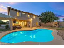 Inviting backyard showcasing a sparkling pool, covered patio, and lush green lawn perfect for outdoor entertaining at 4093 E Dublin St, Gilbert, AZ 85295
