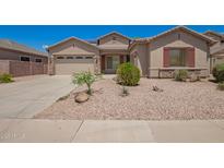 Charming single-story home featuring a low-maintenance desert landscape and a two-car garage at 44574 W Garden Ln, Maricopa, AZ 85139