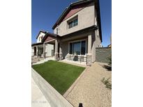 Charming two-story home featuring a cozy front porch with artificial grass and beautiful stone pillar accents at 512 S Soho Ln # 8, Chandler, AZ 85225