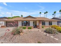 Charming single-story home featuring a well-manicured front yard and a welcoming brick accented entryway at 928 W Natal Ave, Mesa, AZ 85210